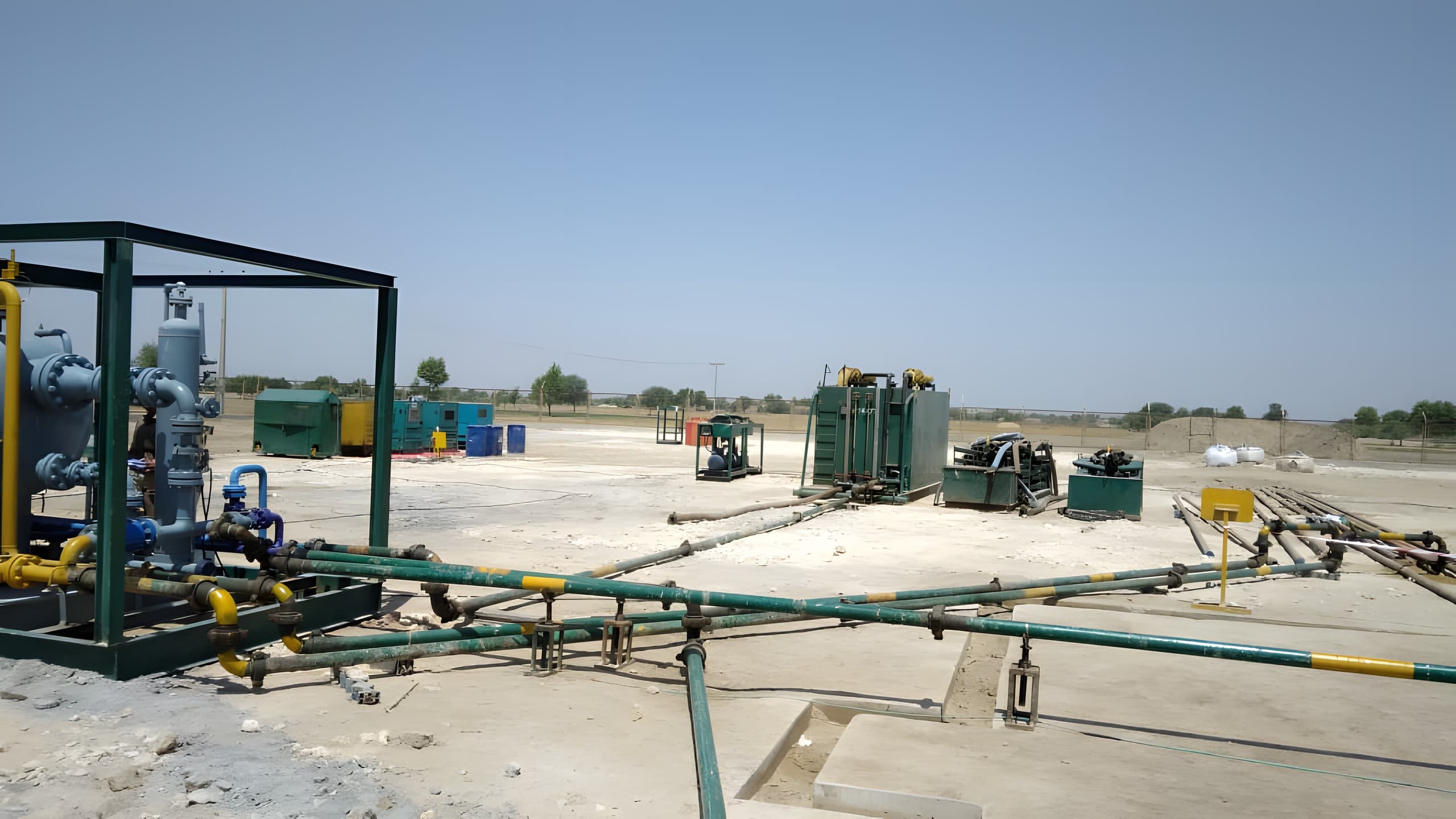 Surface flowlines and well testing equipment skids at a desert wellsite